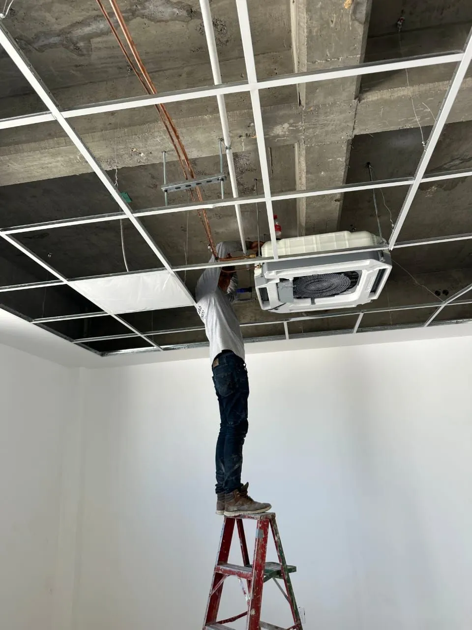 Técnico instalando una unidad interior de un sistema VRF