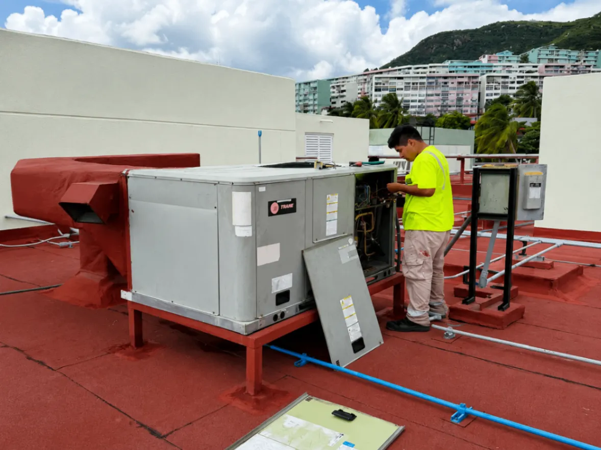 Técnico realizando mantenimiento en una unidad paquete