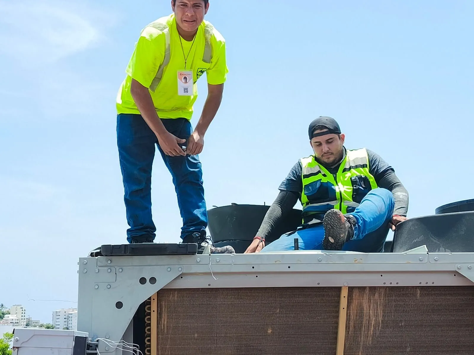 Personal técnico trabajando sobre un equipo HVAC en una azotea