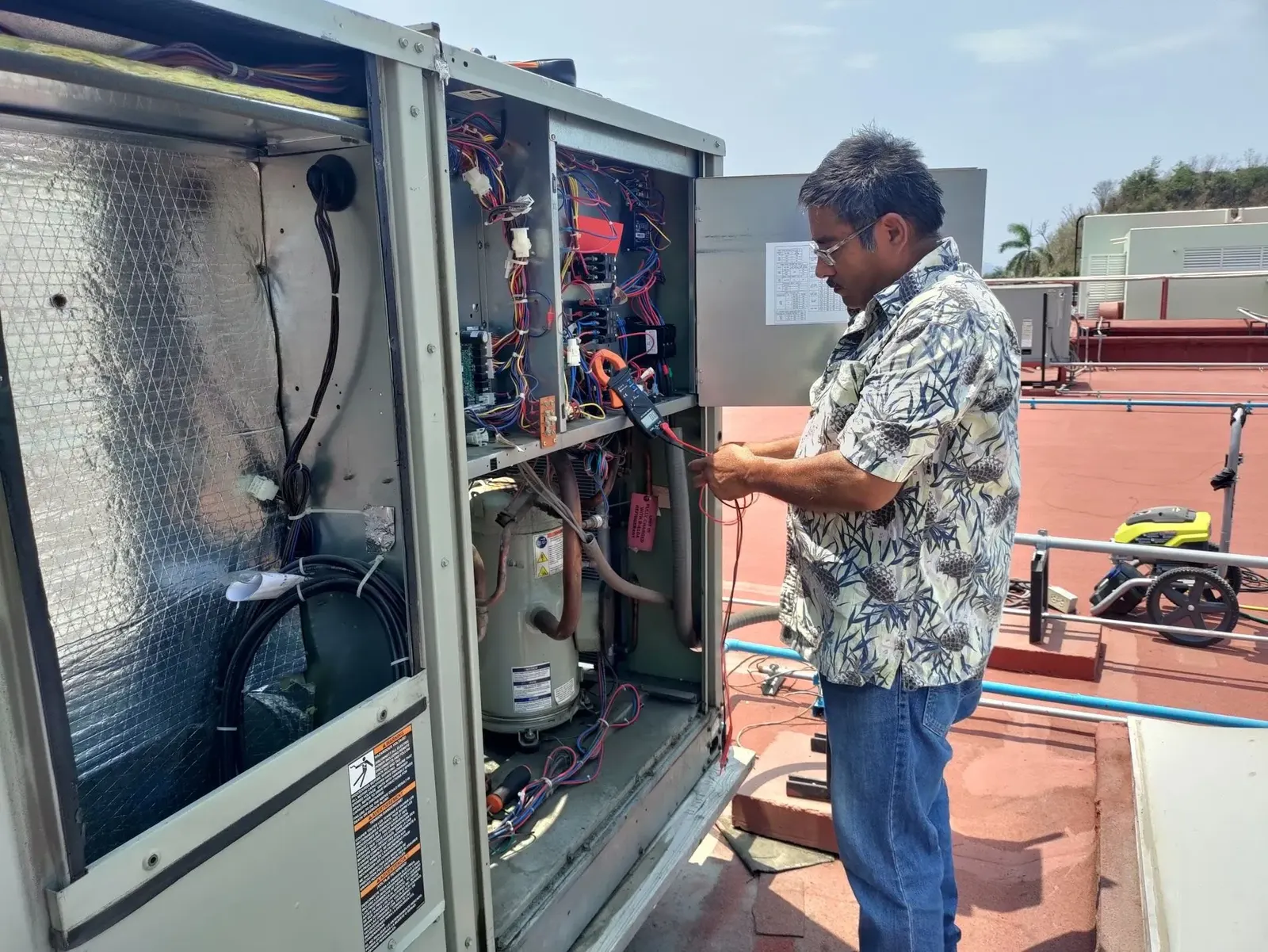 Técnico reparando el sistema eléctrico de una unidad paquete